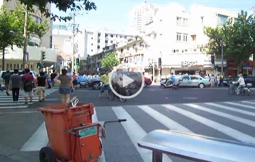 sehr belebte Kreuzung in China mit vielen Menschen, Autos und alle suchen sich ihren Weg auch entgegen einiger Verkehrsregeln.